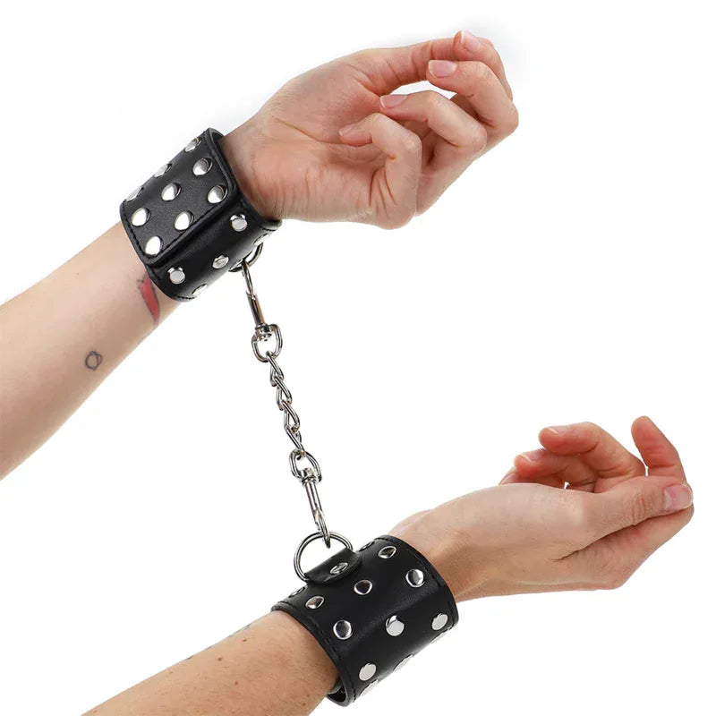 KINK - HANDGELENKFESSELN MIT DRUCKVERSCHLUSS VOLLER NIETEN SCHWARZ VERSTELLBAR 19-24 CM X 5,5 CM - Vanelion Paradise