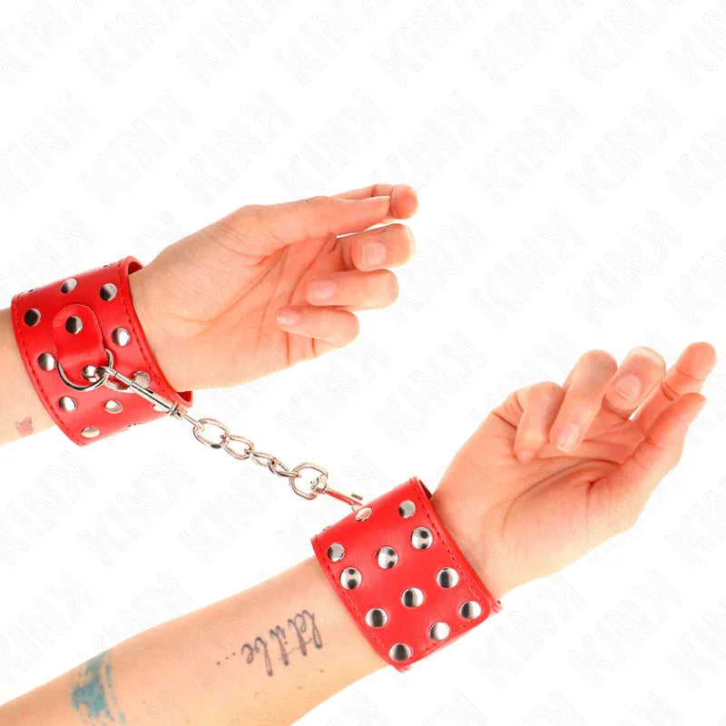 KINK - HANDGELENKFESSELN MIT DRUCKVERSCHLUSS VOLLER NIETEN ROT VERSTELLBAR 19-24 CM X 5,5 CM - Vanelion Paradise