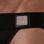 Metallplakette am schwarzen Bund des schwarzen Locker Gear Wide Waistband Jockstraps